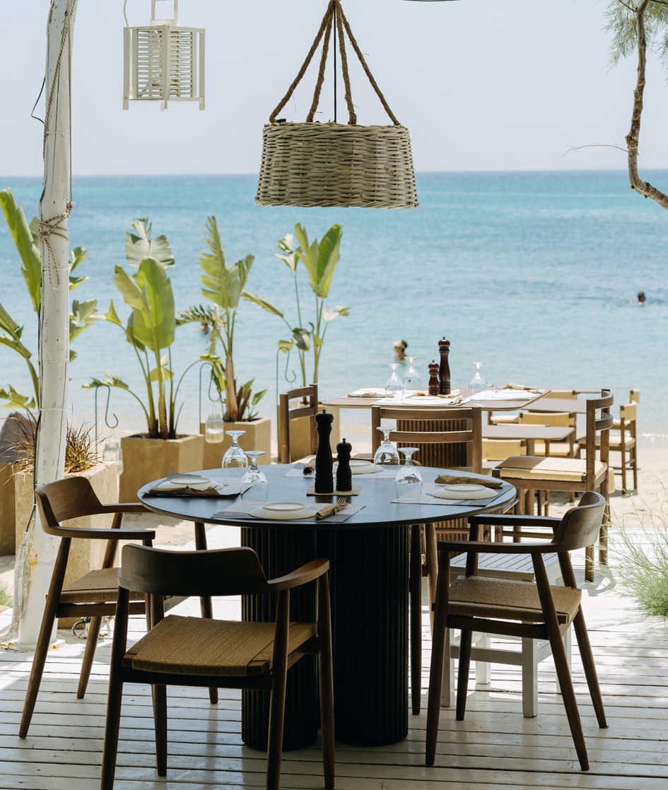 Tables and seating on the sand for beachfront dining at Santana Naxos